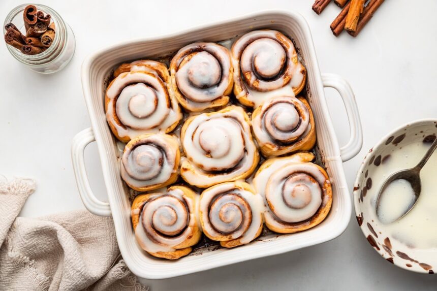 Protein cinnamon rolls in a square baking dish topped with an icing.