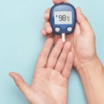 Close up of hands using a blood sugar monitor