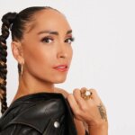 Robin Arzón holding a jacket over her shoulder and looking at the camera