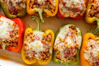 A pan of cooked turkey stuffed peppers with melted cheese.
