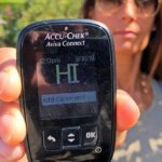 Woman holding blood glucose meter with HI reading